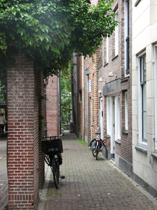 819386 Gezicht in de Strosteeg te Utrecht, vanuit de steeg naar het oosten; op de achtergrond de Oudegracht.